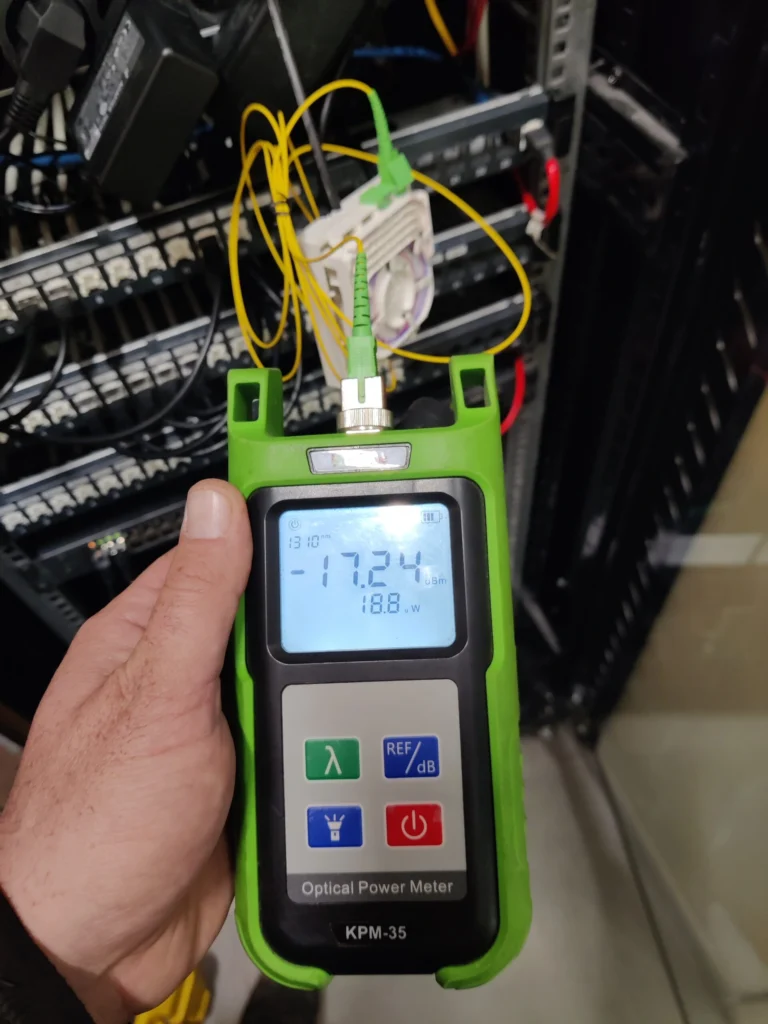 Un photomètre optique en train de mesurer la puissance du signal lumineux d'une fibre optique